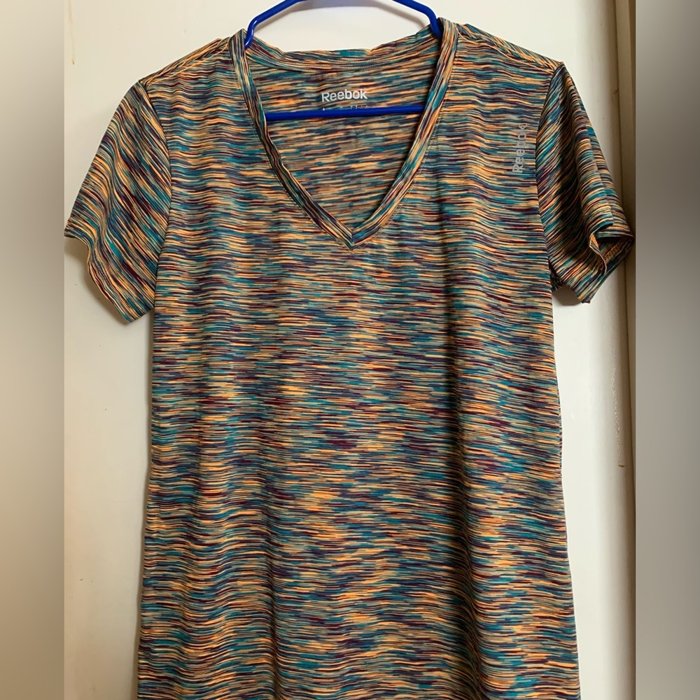 Reebok activewear top. Multi color in tone of orange, purple and teal.